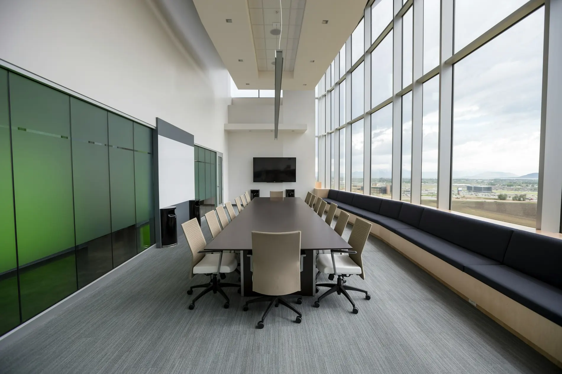 A long boardroom table framed by full-height windows